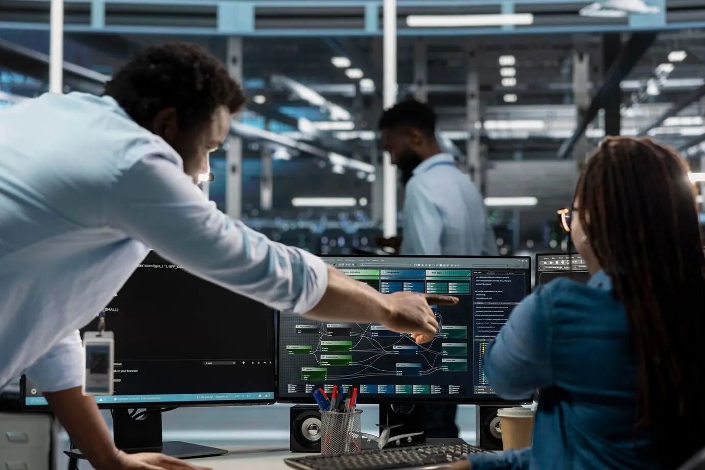 Supervisor del centro de datos supervisando a un administrador que usa una PC para visualizar árboles de nodos de IA.