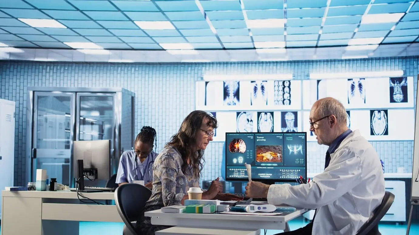 Especialista mayor reuniéndose con una paciente para discutir resultados en un consultorio.